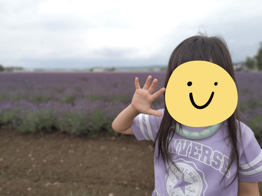 ラベンダー畑の前で手を振る女の子