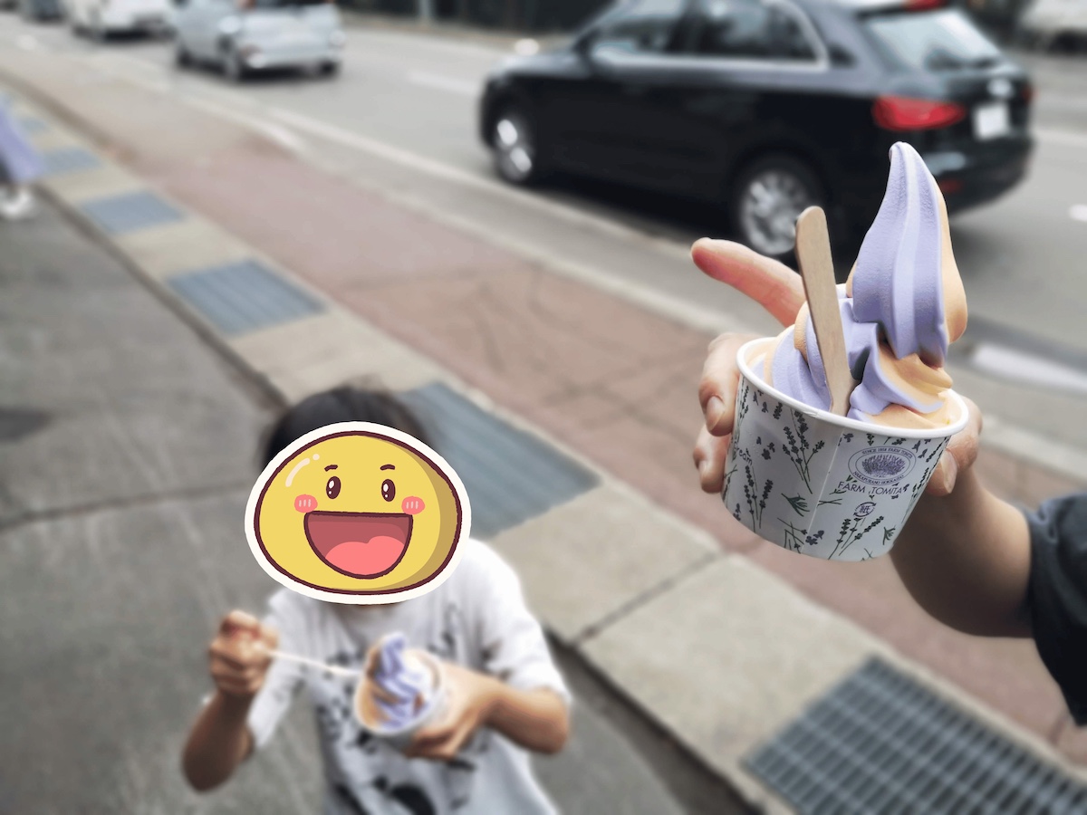 ラベンダーソフトクリームを食べる子ども。ファーム富田のカップ入り