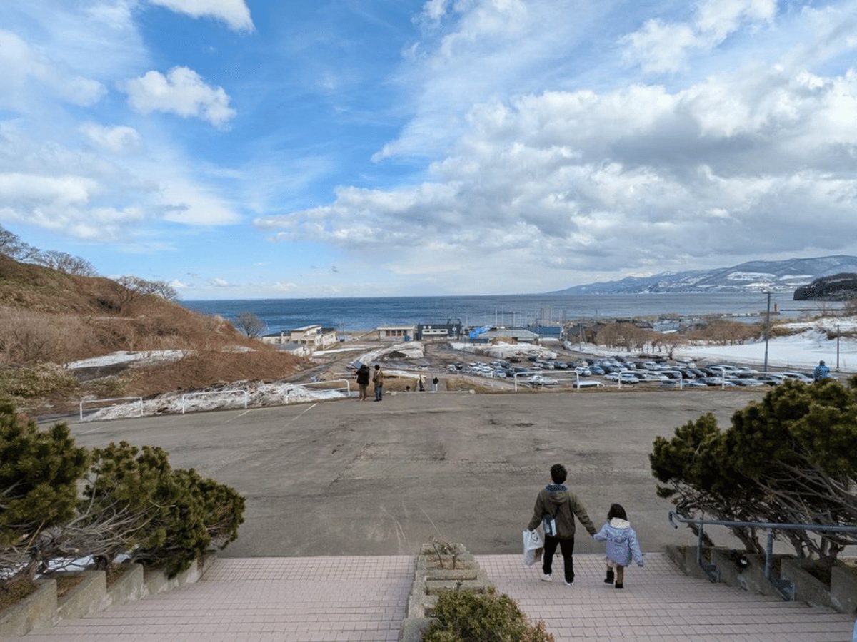 おたる水族館から見える日本海。親子が海に向かって歩いている
