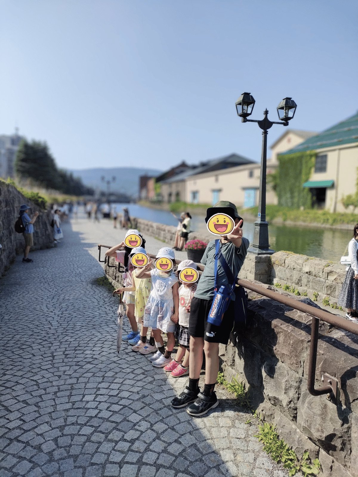 小樽運河沿いを歩く子どもたち。石畳とガス灯が並ぶ